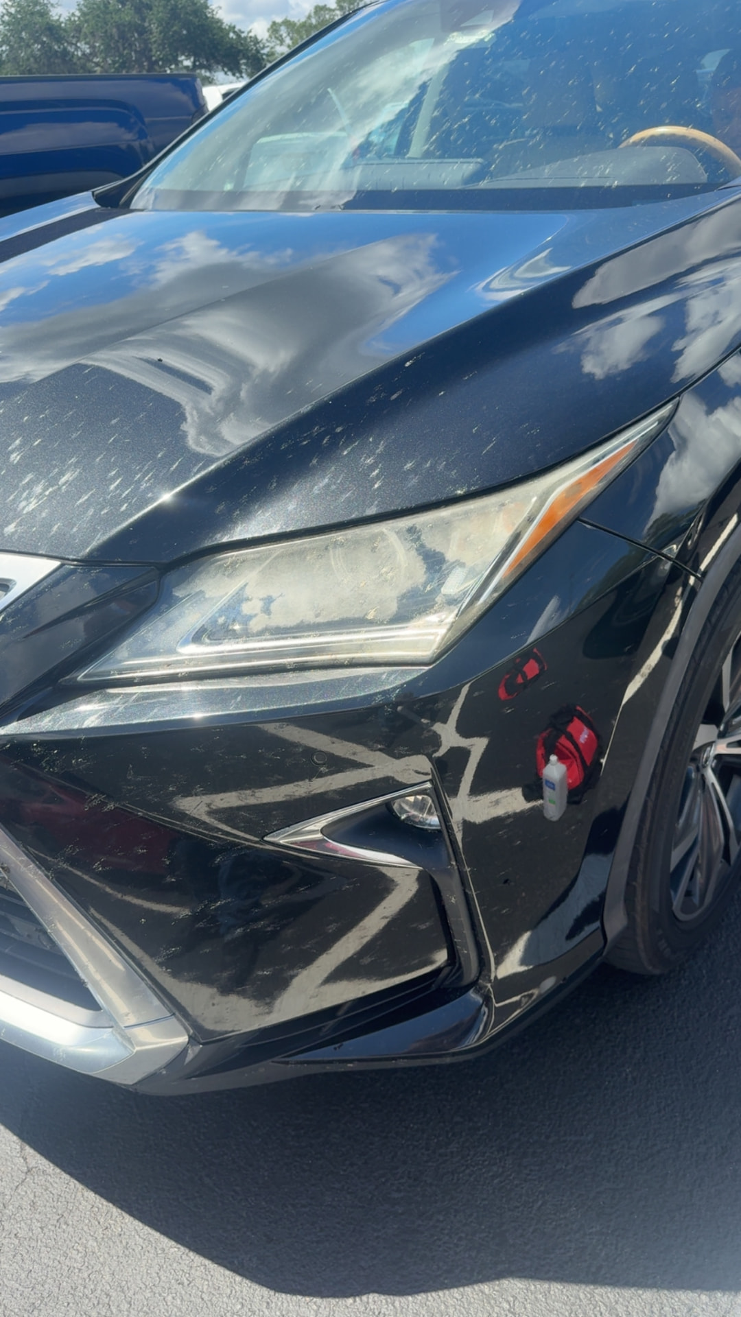 Close-up of a heavily oxidized, hazy headlight lens on a black SUV in Citrus County, Florida